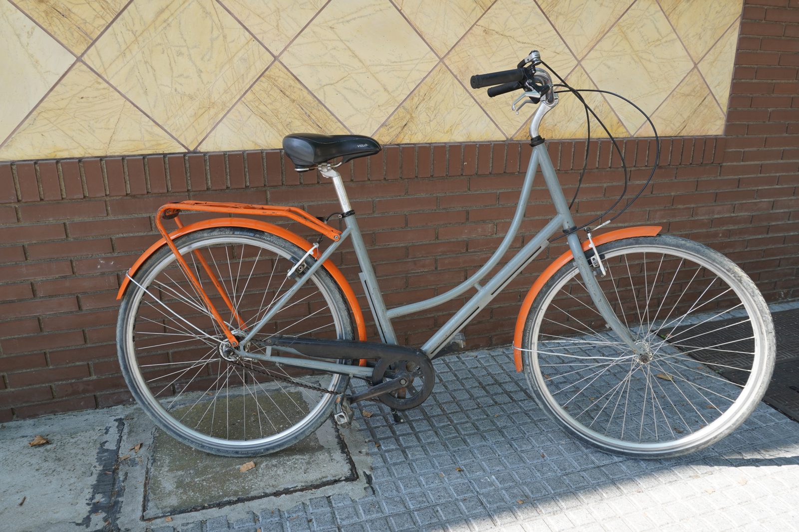 Step-through city bike with orange mudguards and rear rack, for rent at Recyclo in Málaga